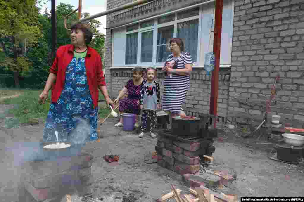 Люди готують їжу на відкритому вогні, селище Новолуганське, червень 2022 року. Із початком повномасштабного вторгнення кількість жертв різко зросла: з лютого 2022-го до листопада 2025 року Росія убила 668 українських дітей, а поранила – 2253