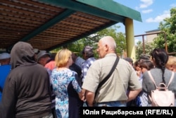 Люди в черзі за гарячими обідами