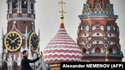 RUSSIA -- A man makes a selfie photo in front of the Kremlin's Spasskaya tower and St. Basil's cathedral in downtown Moscow on September 11, 2023