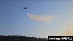 Гелікоптер МНС Росії скидає воду на гору Тепе-Оба під Феодосією під час пожежі. Крим, 26 серпня 2024 року