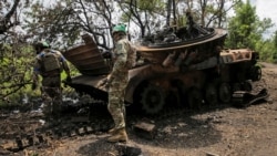 Украинские военнослужащие осматривают уничтоженную российскую БМП-2 в селе Сторожевое Донецкой области, освобожденном от российской армии, 14 июня 2023 года