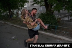 Парень несет на руках раненую девушку. Покровск, 7 августа 2023 года