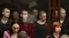 На задньому плані (за склом) ув’язнені українські громадяни в суді у російському Ростові-на-Дону, більшість із них – військовополонені, бійці полку «Азов». Росія, Ростов-на-Дону, 14 червня 2023 року