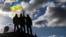 U.K. – Ukrainian personnel hold a Ukrainian flag as they stand on a Challenger 2 tank during training at Bovington Camp, near Wool in southwestern Britain, February 22, 2023