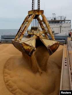Пшеницу загружают на судно в оккупированном Мариуполе перед его отправкой в российский город Ростов-на-Дону, 25 октября 2023 года