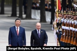 Президент Китая Си Цзиньпин (слева) и руководитель России Путин идут мимо почетного караула в Пекине. Китай, 2024 год