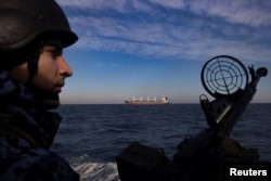 Украинский морской пограничник наблюдает за судном, вышедшим из порта Украины и следовавшим в Черное море. Февраль 2024 года