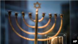 O menorah din orașul german Kiel, cu o fotografie de epocă amintind Holocaustul, expusă în ianuarie 2023 la Parlamentul Germaniei, Bundestag, din Berlin. (Foto: AP /Markus Schreiber)