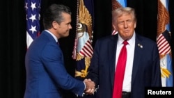 Дональд Трамп приветствует военного министра США Пита Хегсета в начале их выступлений перед высшим военным руководством страны на базе морской пехоты в Куантико. Штат Вирджиния, 30 сентября 2025 года