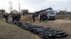 Ексгумовані українськими слідчими органами тіла жителів Бучі, убитих за даними слідства під час російської окупації міста. Буча, Україна. 8 квітня 2022 року