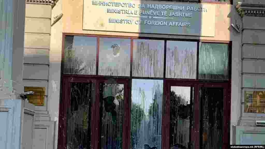 Скршени стакла од влезот на зградата на МНР за време на синоќешните протести. Штетата изутрината во 9 часот се уште не беше санирана