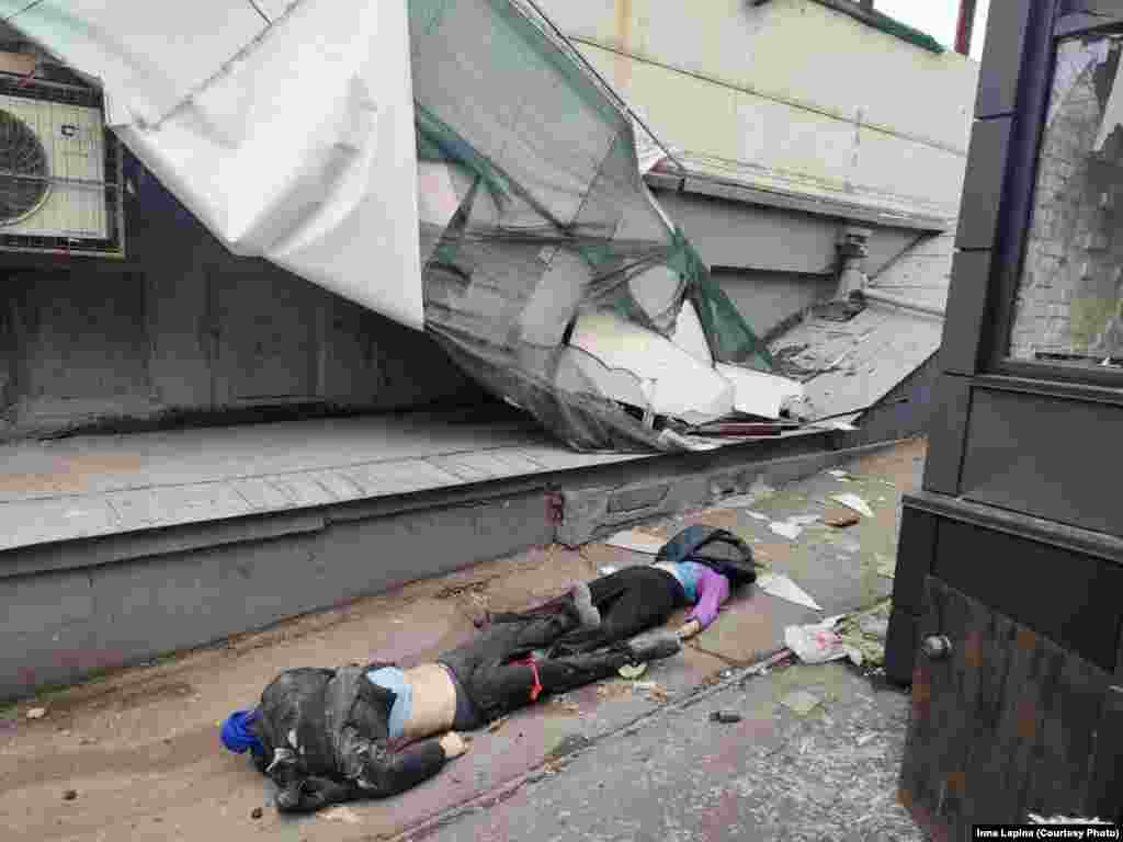 Cadavre de civili pe jos lângă o clădire distrusă din Mariupol. Se estimează că, până la 12 martie, 1.500 de civili au fost uciși în acest oraș.