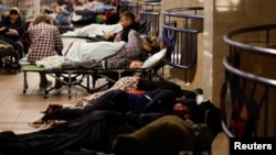 Люди ховаються всередині станції метро під час ракетного обстрілу та атаки безпілотника в Києві, 28 серпня 2025 року