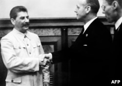 Генеральный секретарь ЦК ВКП(б) Иосиф Сталин пожимает руку министру иностранных дел нацистской Германии Иоахиму фон Риббентропу после подписания пакта Молотова-Риббентропа. Москва, 23 августа 1939 года