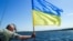 UKRAINE – Ukrainian Cossack on the Dnipro with the Flag of Ukraine 