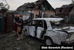 Местные жители рядом с домом, разрушенным в результате российского удара по Покровску, 15 июня 2022 года