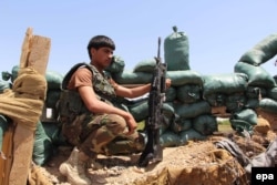 Сотрудник афганских сил безопасности занимает позицию во время операции против боевиков Талибана в округе Над Али провинции Гильменд, 27 апреля 2016 года