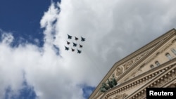 Avioane de vânătoare ale armatei ruse zboară în formație deasupra Teatrului Bolșoi în timpul unei repetiții pentru o paradă aeriană.