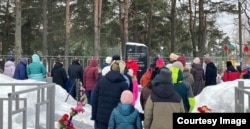 Люди у братского захоронения в Деревянном