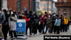 Вакцина алуу үчүн кезекке турган британиялыктар. Манчестер, Британия, 14-декабрь, 2021-жыл.