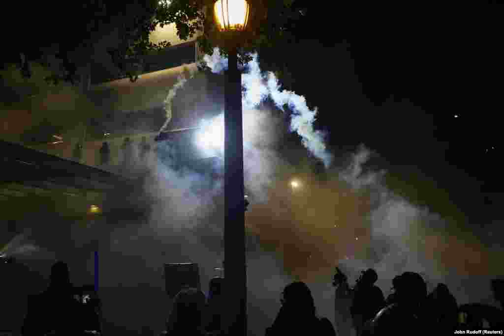 Демонстрант кидає гранату зі сльозогінним газом назад у будівлю ICE (Міграційна та митна правоохоронна служба США) під час акції протесту «Ні королям» проти політики президента США Дональда Трампа в Портленді, штат Орегон, 18 жовтня 2025 року