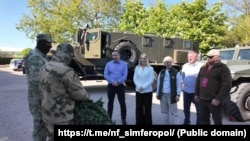 Представники сакського санаторію «Північне сяйво» та кримські активісти російського «Народного фронту» передають маскувальні сітки російським військовим під час повномасштабного вторгнення РФ в Україну, травень 2025 року