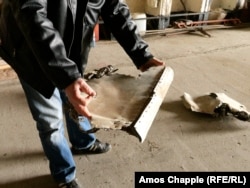 Член аэроклуба "Миловице" держит в руках части советского истребителя, который, по его словам, был уничтожен с помощью взрывчатки во время вывода советских войск 35 лет назад