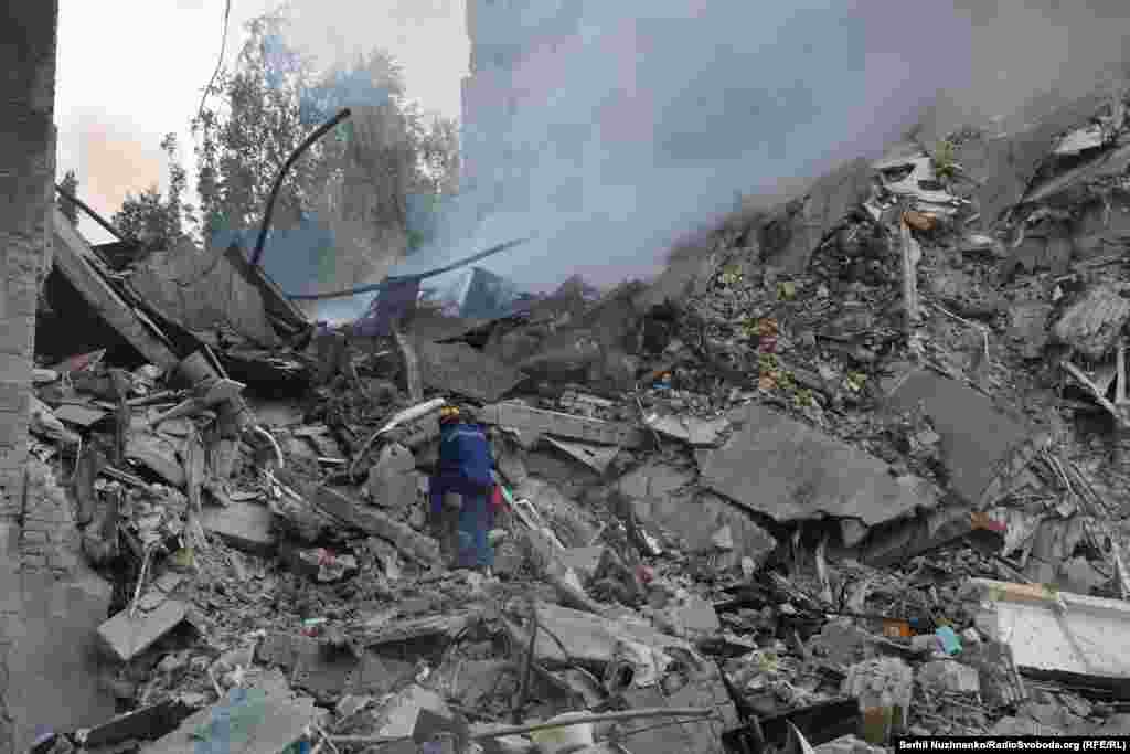 Спасатель в поисках людей, которые могли бы остаться под завалами