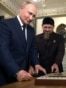Kadyrov (C) shows Koran to Russia's President Vladimir Putin (L) during his visit to Chechnya in Grozny