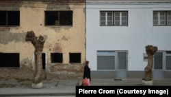 Žena u Srebrenici hoda pored zgrade uništene u ratu, 19. novembar 2015. 