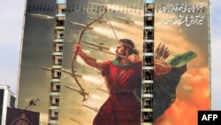 Огромная пропагандистская картина на здании в центре Тегерана, на которой изображен "Араш Лучник", одна из центральных фигур древней персидской мифологии, выпускающий стрелы и баллистические ракеты по врагам родины. Июнь 2025 года