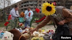 Люди несуть іграшки і квіти на дитячий майданчик після російського удару по Кривому Рогу, 5 квітня 2025 року