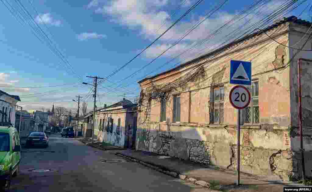 Volodarskiy soqağında keçenlerde asfalt töşegenler, amma ev fasadları ve temelleri eski qala, tamir etilmeli, Aqmescit, 2025 senesi yanvar ayı