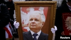 Еден човек држи фотографија од Лех Качински за време на церемонијата за сеќавање на покојниот полски претседател во Варшава во февруари 2016 година.