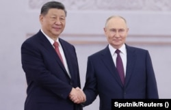 Президент России Владимир Путин жмет руку своему китайскому коллеге Си Цзиньпину во время приветственной церемонии перед переговорами в Кремле в Москве, Россия, 8 мая 2025 года