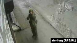 Російський солдат цілиться у вуличну камеру під час окупації міста Буча. Київщина, Україна. Березень 2022 року