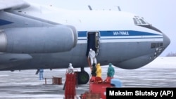 Medical personnel prepare to help Russian travelers transported from China aboard a Russian military plane at an airport outside Tyumen on February 5.