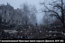 Український військовослужбовець йде вулицею поміж житлових будинків, пошкоджених внаслідок російського військового удару. Костянтинівка, Донецька область, 28 листопада 2025 року