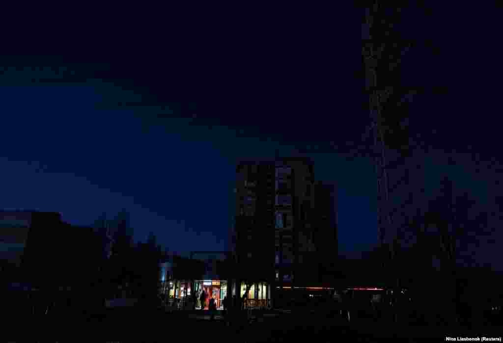 Жители Одессы стоят возле одного из ресторанов, который работает на генераторе, после того, как критически важная гражданская инфраструктура города пострадала от недавних российских ракетных и беспилотных атак. 13 декабря 2025 года.