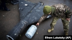 Украинский военный показывает термобарический заряд сбитого беспилотника Shahed, запущенного Россией. Исследовательская лаборатория, 14 ноября 2024 года