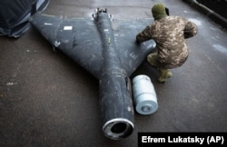Украинский военный осматривает сбитый ранее беспилотник Shahed с термобарическим зарядом, запущенный Россией, 14 ноября 2024 года