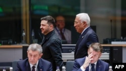 Прэзыдэнт Украіны Ўладзімір Зяленскі (у цэнтры зьлева) ідзе разам са старшынёй Эўрапейскай рады Антонію Коштам (у цэнтры справа) падчас саміту ЭЗ у Бруселі. Прэм'ер-міністар Чэхіі Андрэй Бабіш (зьлева) і прэзыдэнт Францыі Эманюэль Макрон (справа) сядзяць наперадзе