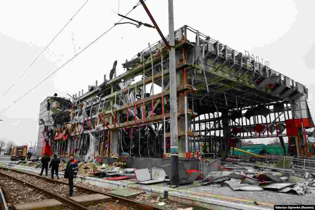 Працівники залізниці оглядають зруйновану російською атакою будівлю вокзалу у Фастові