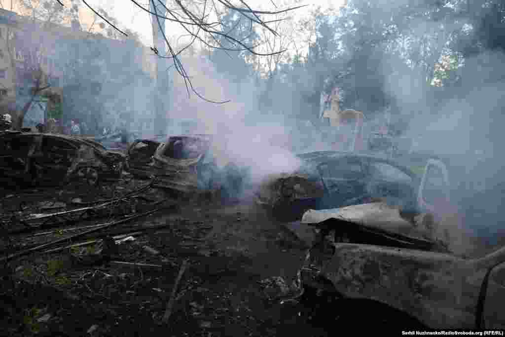 Обгоревшие автомобили во дворе дома, в который попала российская ракета