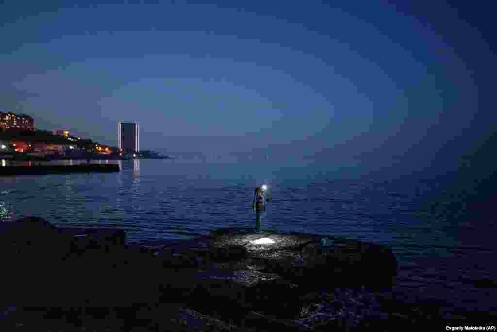 Одессада Аркадия пляжында ир балык тота. 