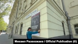 Сотрудник театра в Севастополе снимает афишу спектакля "Ветер шумит в тополях" режиссера Римаса Туминаса после отмены гастролей московского театра им. Вахтангова местными властями