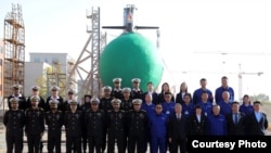 Кинески и пакистански морнарички претставници позираат за време на церемонијата по повод лансирањето на подморницата „Гази“ во Вухан, Кина, на 17 декември