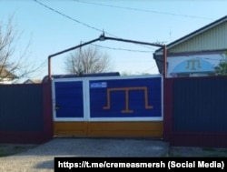 Оформлення паркану в синьому та жовтому кольорах у приватному будинку села Урожайне Совєтського району під час повномасштабного вторгнення РФ в Україну, квітень 2025 року