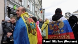 Люди стоят в очереди возле избирательного участка, расположенного в посольстве Молдовы, во время парламентских выборов в стране. Москва, Россия, 28 сентября 2025 года