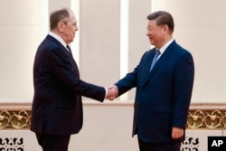 Председатель КНР Си Цзиньпин приветствует министра иностранных дел России Сергея Лаврова, прилетевшего на встречу глав МИДов государств-членов Шанхайской организации сотрудничества в Пекине. 15 июля 2025 года